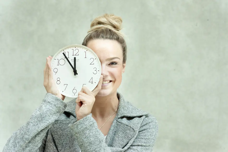 a woman holds a clock