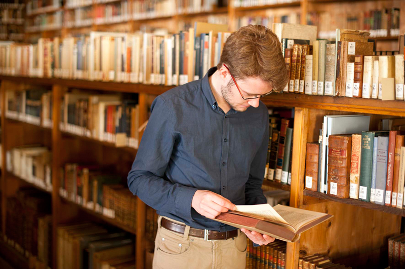 Ein junger Mann liest ein Buch in der Forschungsbibliothek Gotha der Universität Erfurt