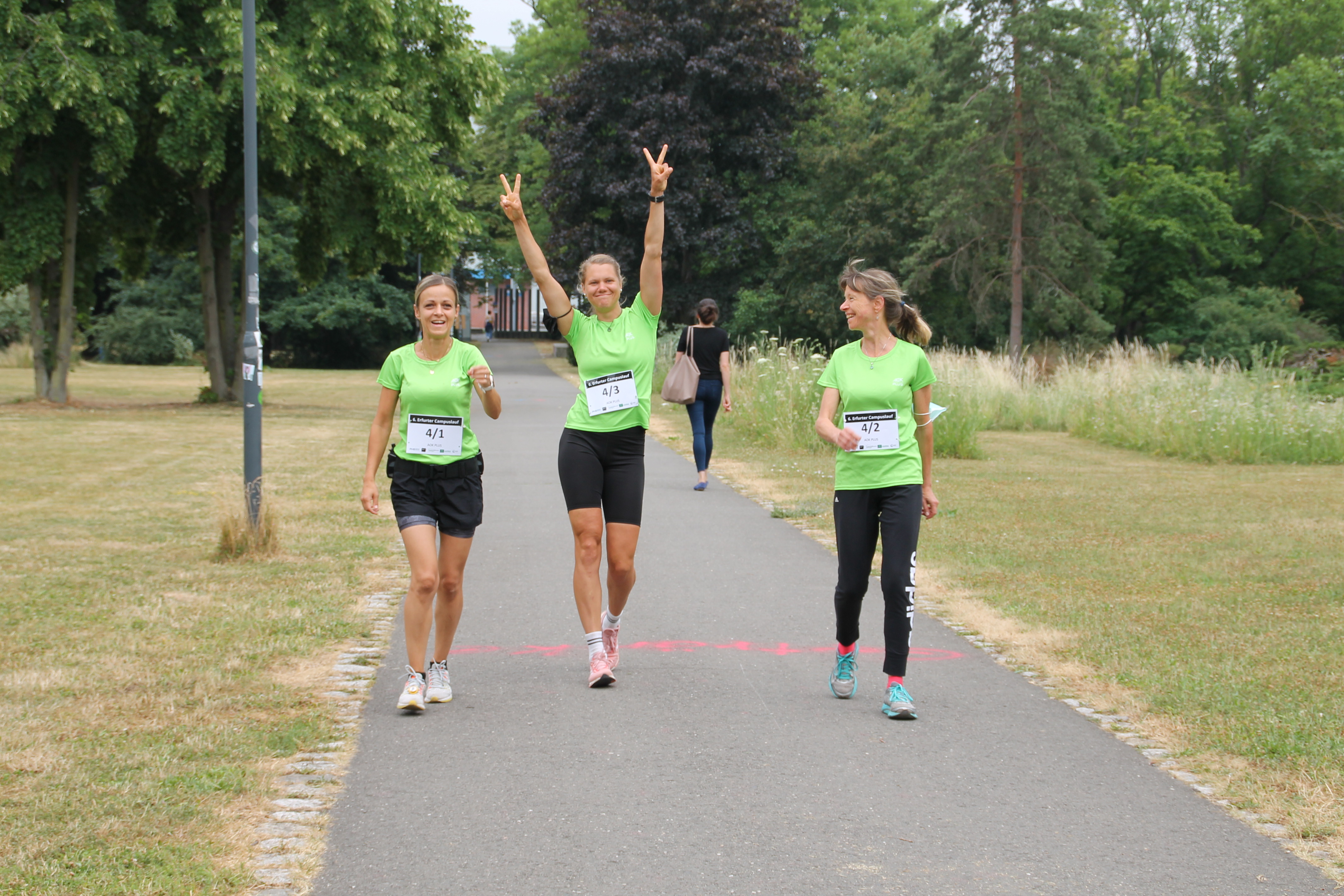 Drei Läuferinnen im grünen T-Shirt