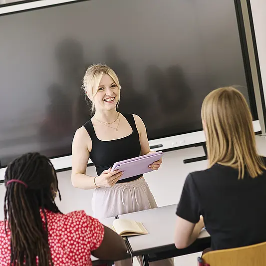 Studentin vor Tafel im Seminarraum