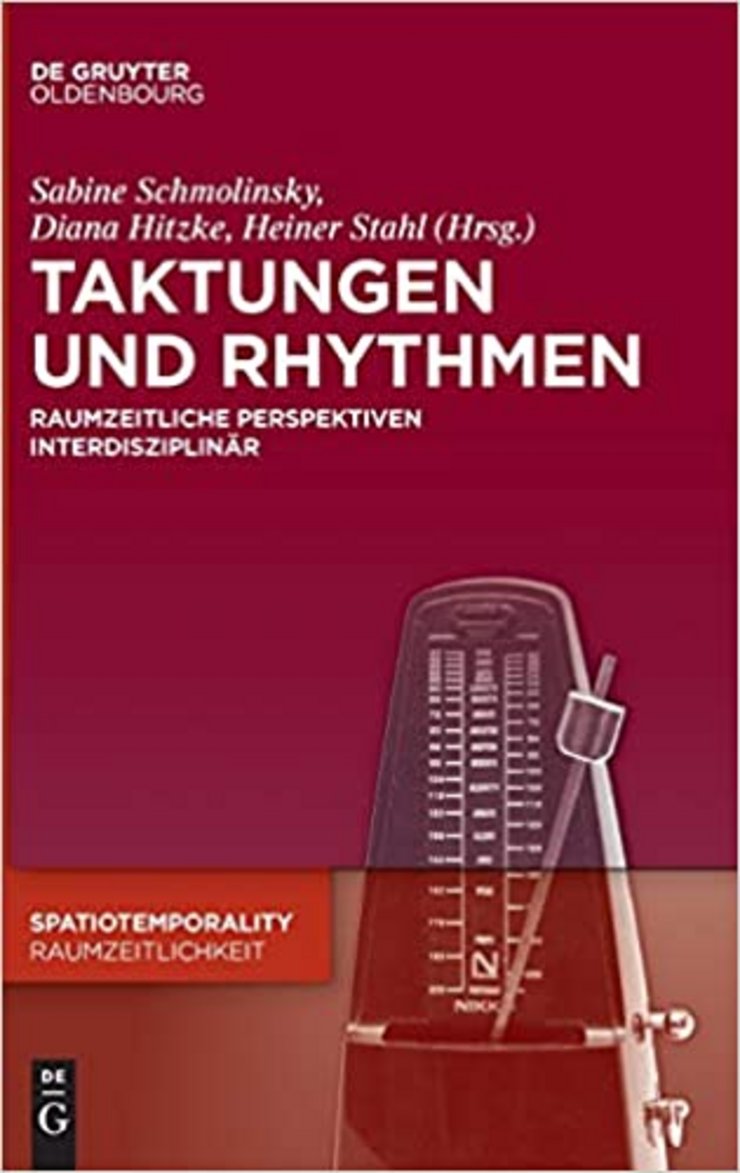 The picture shows the cover of the second volume of the SpatioTemporality Series. In the background there is a metronome.  
