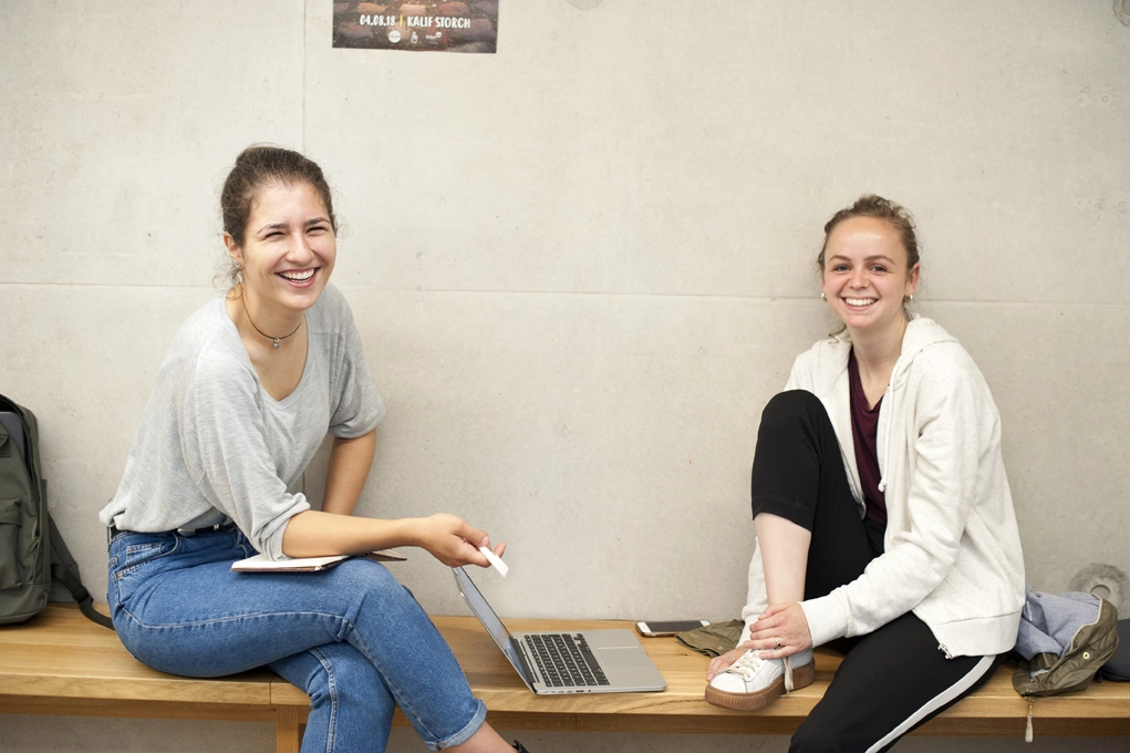 Studentinnen auf Bank vor Hörsaal