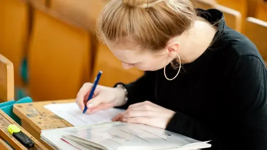 Eine Studentin sitzt in einem Hörsaal der Universität Erfurt