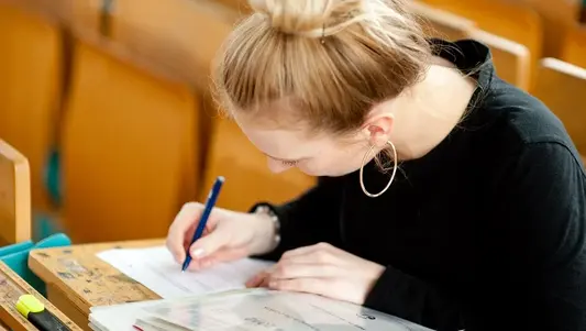 Eine Studentin sitzt in einem Hörsaal der Universität Erfurt