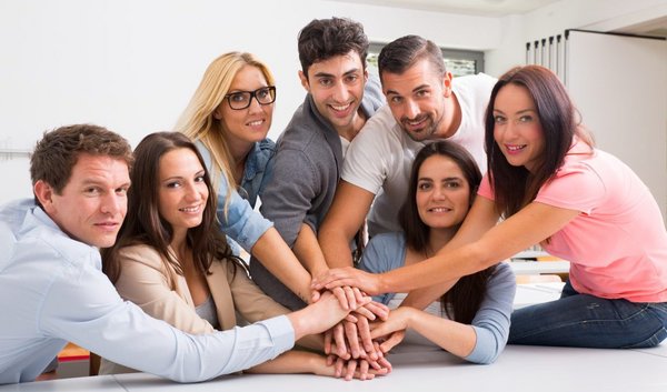 Symbolbild Teamarbeit (mehrere Menschen legen ihre Hände aufeinander zum Ausdruck von Teamarbeit)