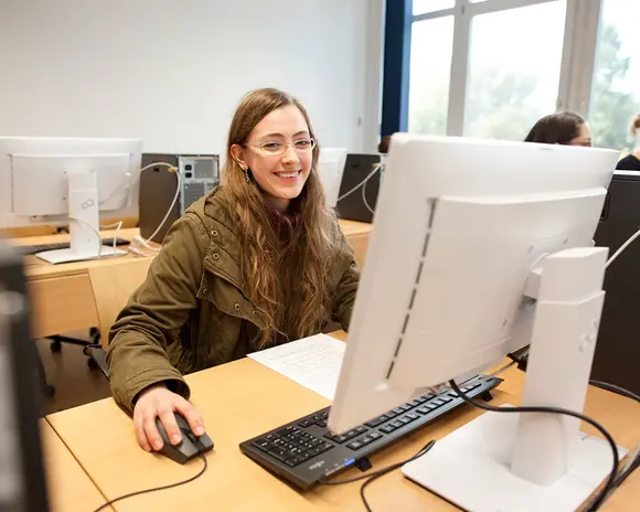 Eine Studentin sitzt an einem Rechner-Arbeitsplatz an der Universität Erfurt