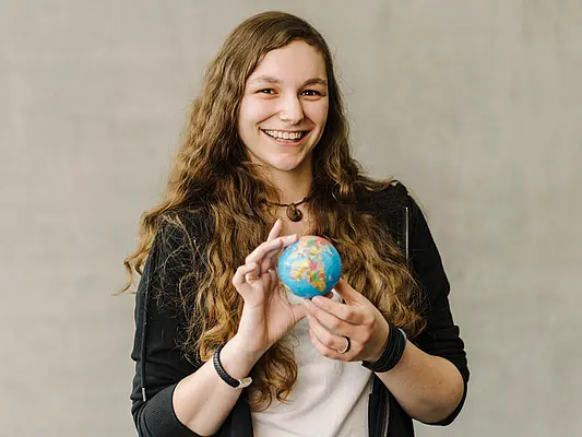 Studentin mit Globus Auslandssemester