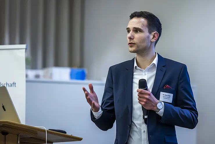 Kevin Tiede hält einen Vortrag mit Mikrofon in der Hand