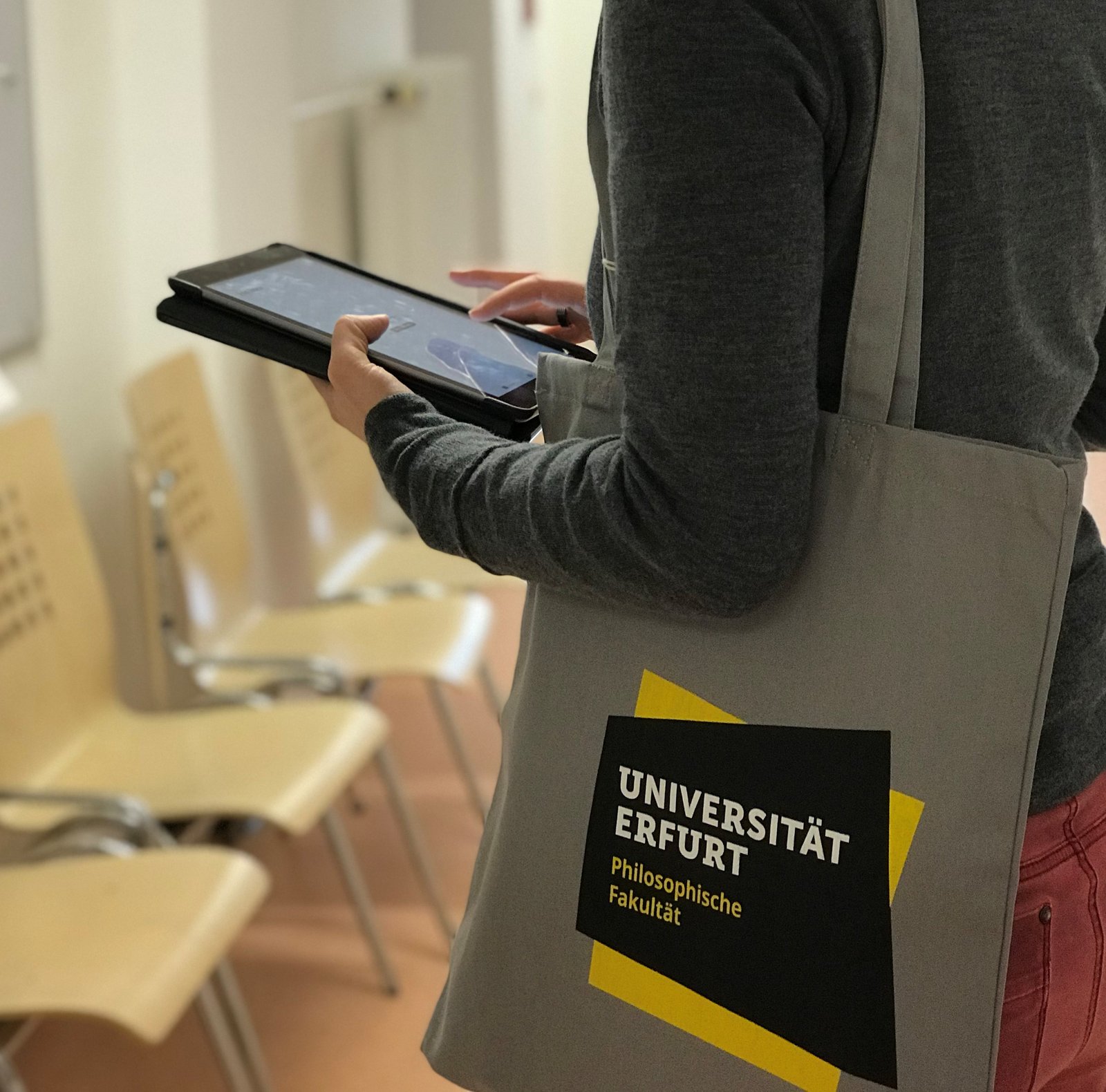 Studierende mit Tablet und einer Uni-Erfurt Tasche