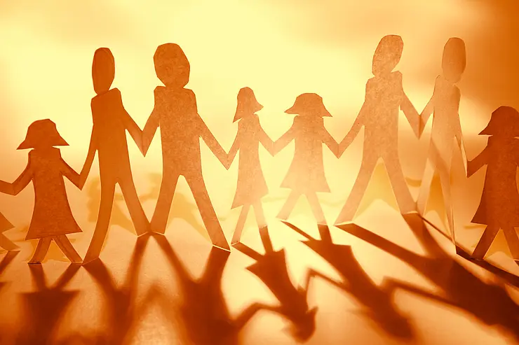 Papiermenschen halten sich an den Händen