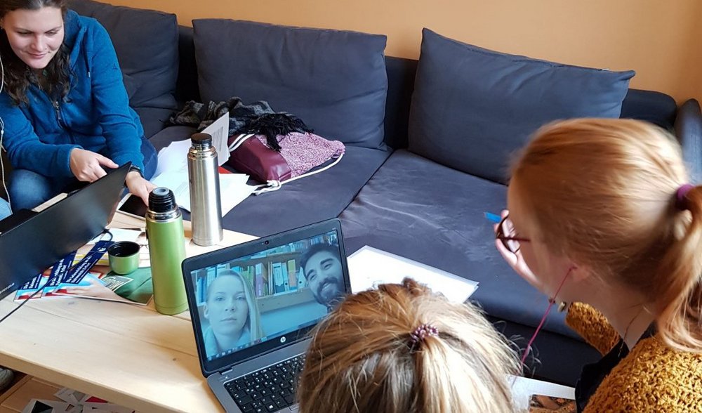 Studierende der Uni Erfurt sitzen mit Laptops über eine Video-Konferenz mit Studierenden der Uni Siegen im Rahmen des gemeinsamen Kooperationsseminars zusammen 