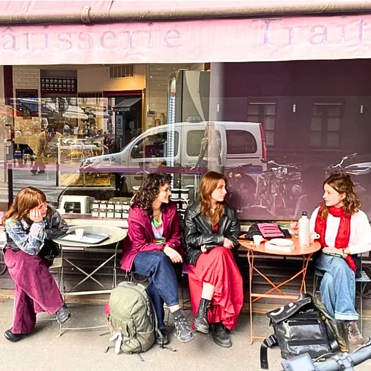 Vier Freundinnen sitzen vor einem Cafe in Paris und unterhalten sich, eine von ihnen ist Anina