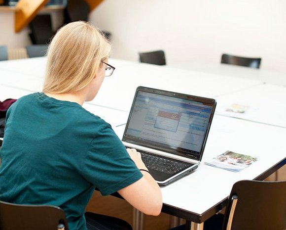 Eine Studentin arbeitet an einem Laptop an der Universität Erfurt