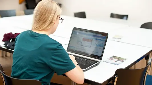 Eine Studentin der Uni Erfurt sitzt an einem Laptop