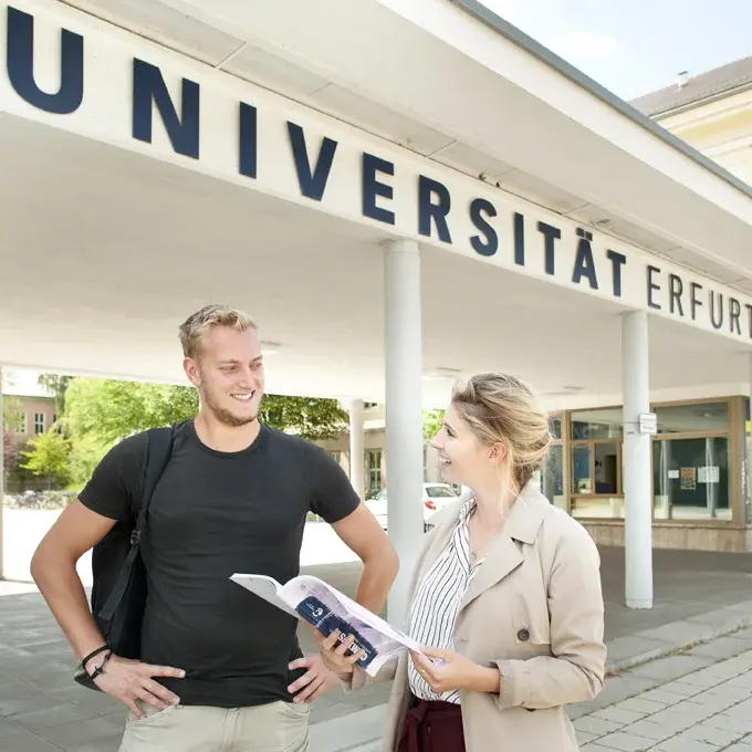 Studentin und Student vor dem Haupteingang der Uni Erfurt
