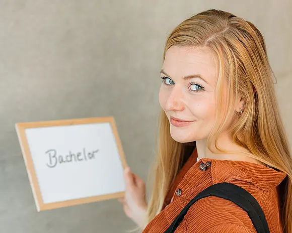 Bachelor-Studentin mit Schild