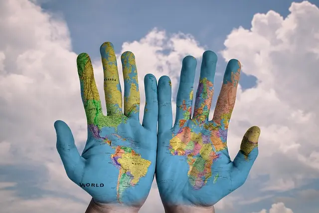 hands with a world map