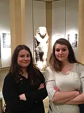Zwei Frauen vor einer Statue