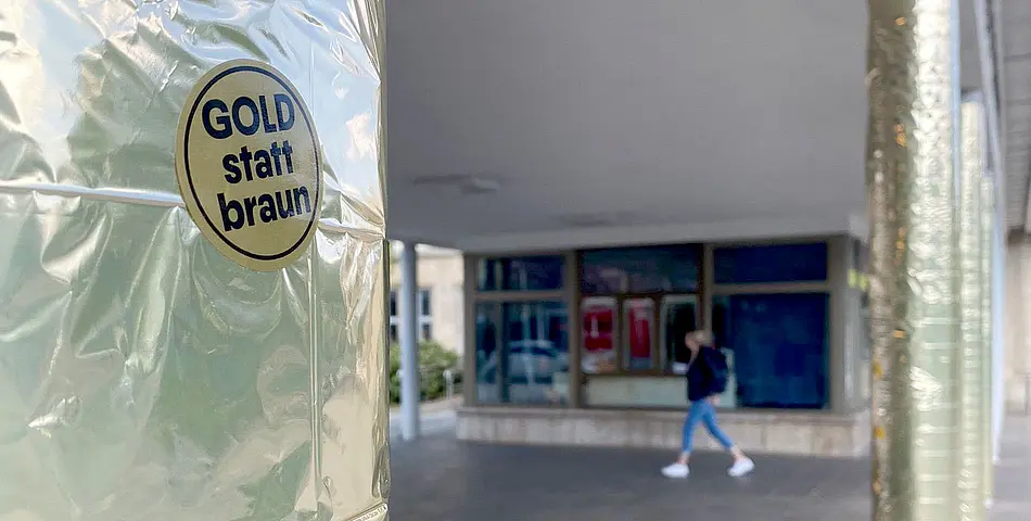 Goldfolie an den Säulen des Eingangs zum Campus