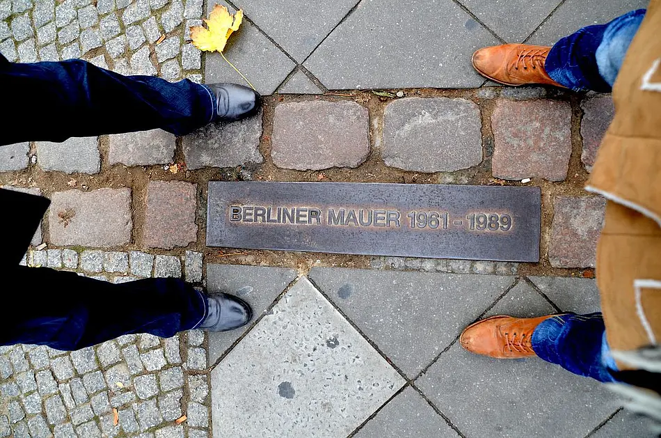 zwei Personen am ehemaligen Grenzstreifen in Berlin