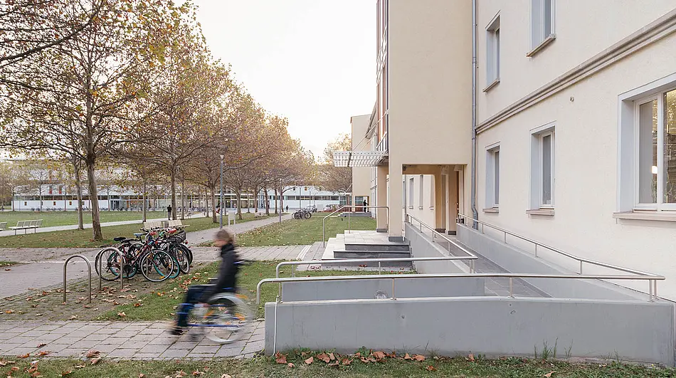 Persona im Rollstuhl auf dem Campus