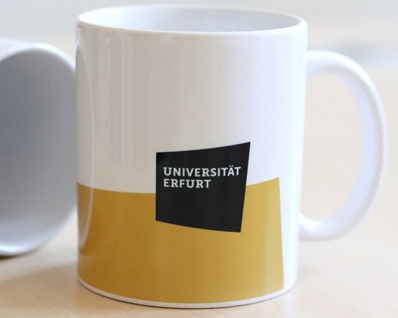 Kaffeetasse mit gelber Fläche und Logo der Uni Erfurt