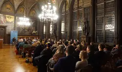 Blick in den Festsaal des Erfurter Rathauses auf das Publikum und die Moderator*innen der Podiumsdiskussion "Theologie im Gespräch"
