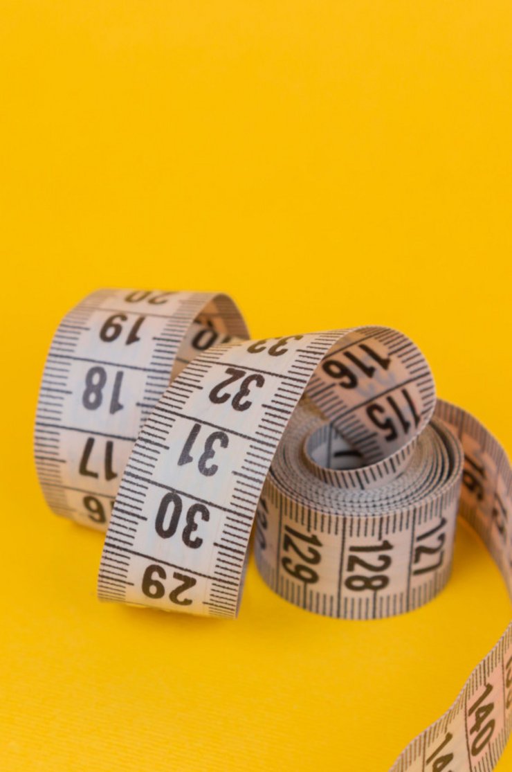 Measuring tape against yellow background