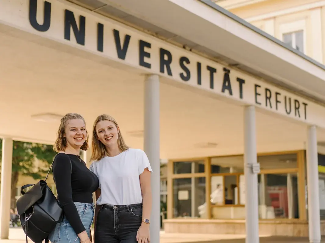 Zwei Studierende vor dem Haupteingang der Uni Erfurt