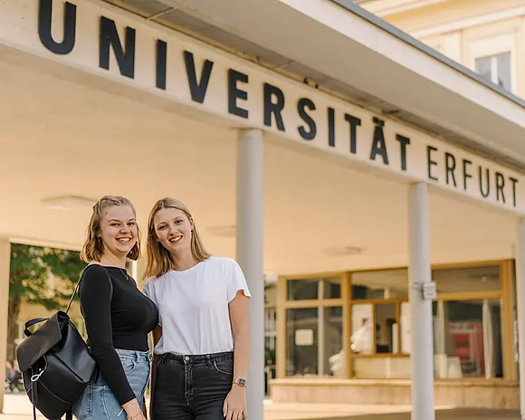 Zwei Studierende vor dem Haupteingang der Uni Erfurt