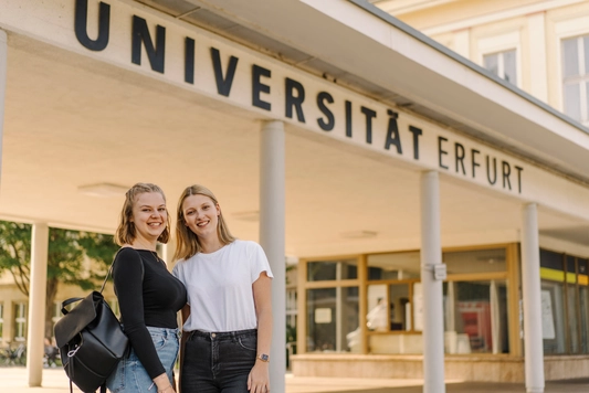 Zwei Studierende vor dem Haupteingang der Uni Erfurt