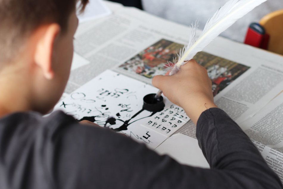 ein Kind schreibt mit Tinte und Feder