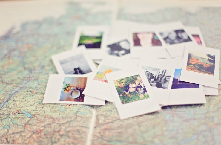 Polaroid-Fotos liegen auf einer Weltkarte