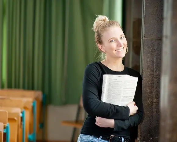Eine Studentin steht in einem Hörsaal der Universität Erfurt