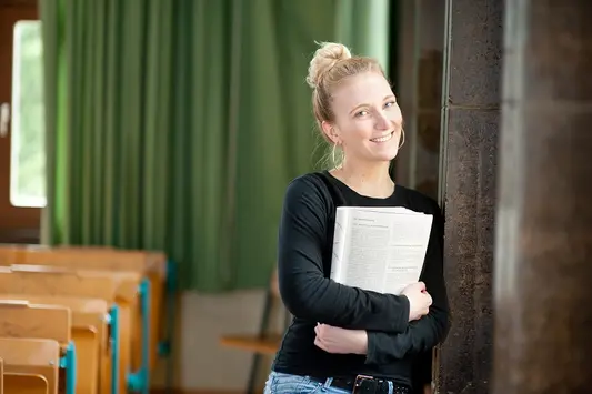 Eine Studentin steht in einem Hörsaal der Universität Erfurt