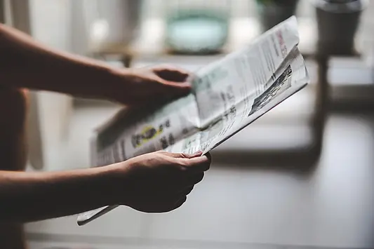 Jemand hält eine Zeitung in der Hand
