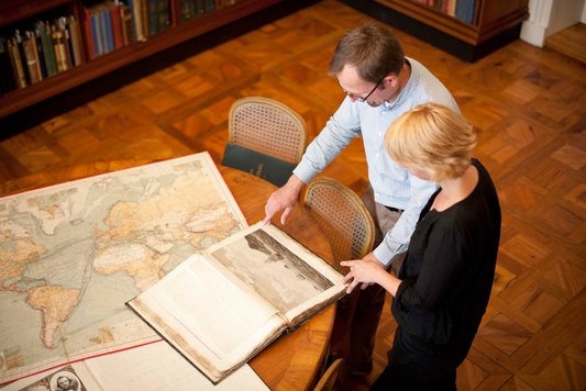 Personen schauen auf Karten in der Forschungsbibliothek Gotha