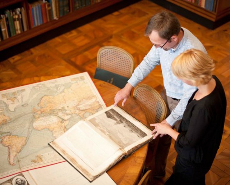 Personen schauen auf Karten in der Forschungsbibliothek Gotha