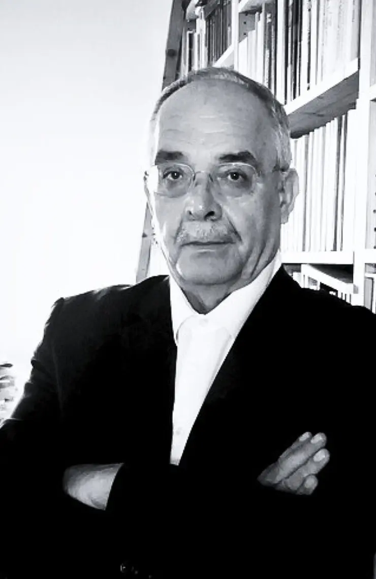 Schwarzweiss-Portraaetfoto von Prof. Dr. Frank Ettrich, mildes Laecheln mit Blick in Kamera, runde Brille, weisses Hemd ueber schwarzem Jackett