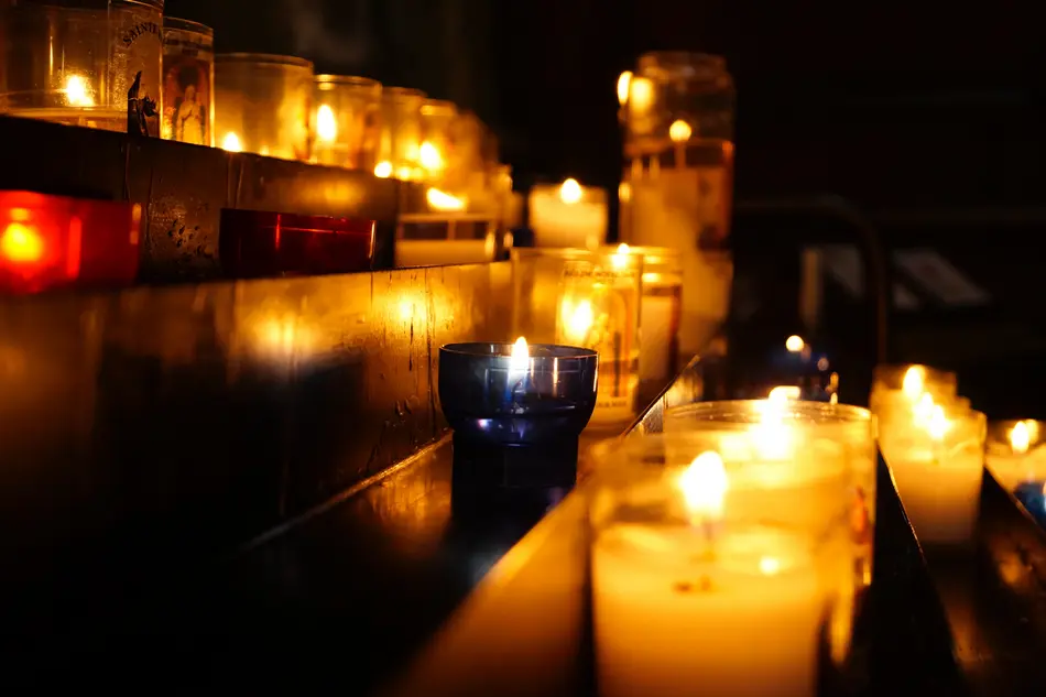 angezündete Kerzen leuchten vor dunklem Hintergrund auf Treppenstufen