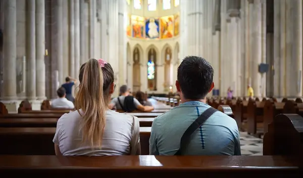 Zwei Junge Menschen von hinten, die auf einer Bank in der Kirche sitzen