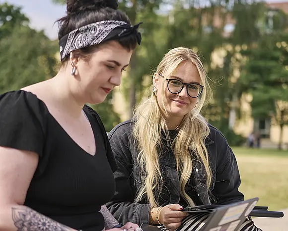 Studentinnen auf dem Campus mit Laptop