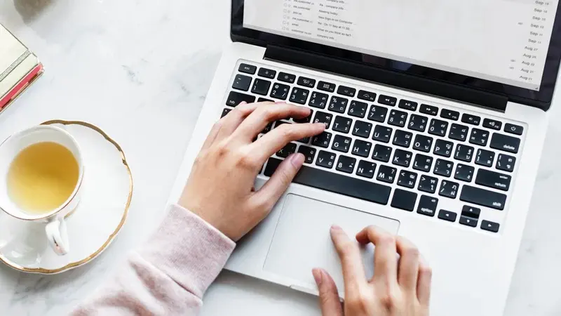 Jemand schreibt auf einem Laptop