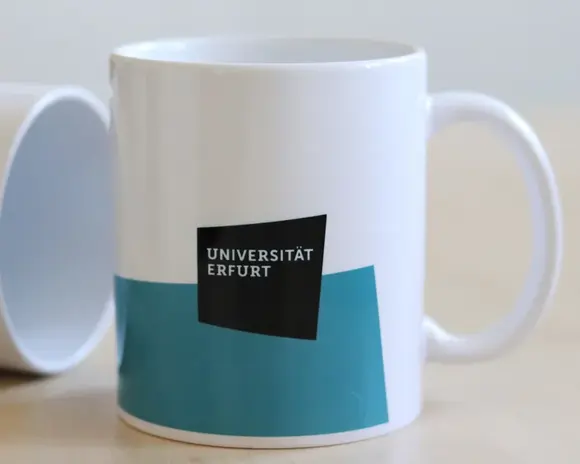 Kaffeetasse mit petrol-farbiger Fläche und Logo der Uni Erfurt