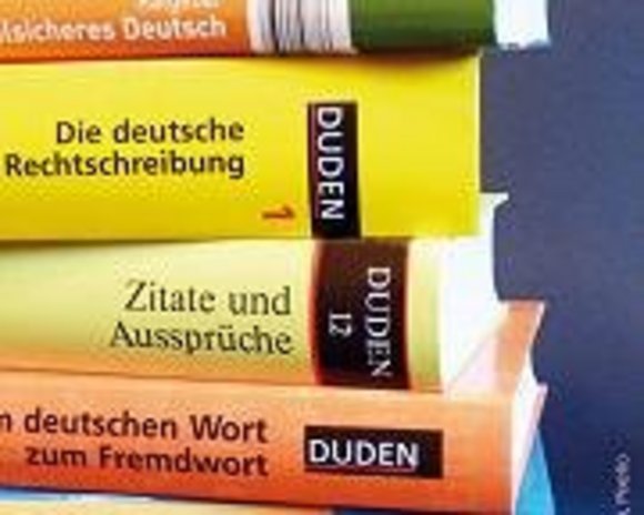 Auf dem Bild ist ein Stapel deutscher Lexika und Duden abgebildet.