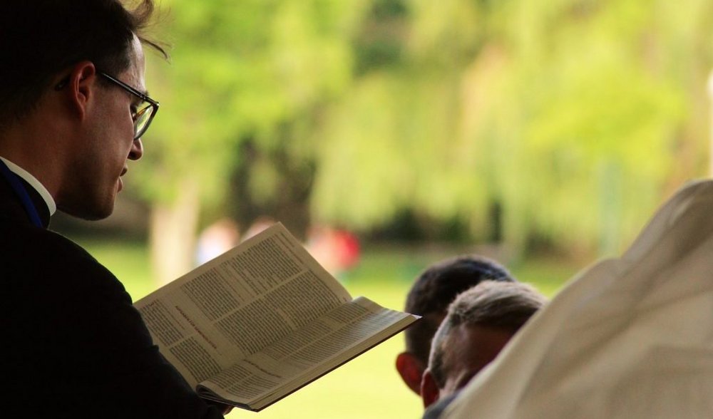 Ein Priester liest in einer Bibel