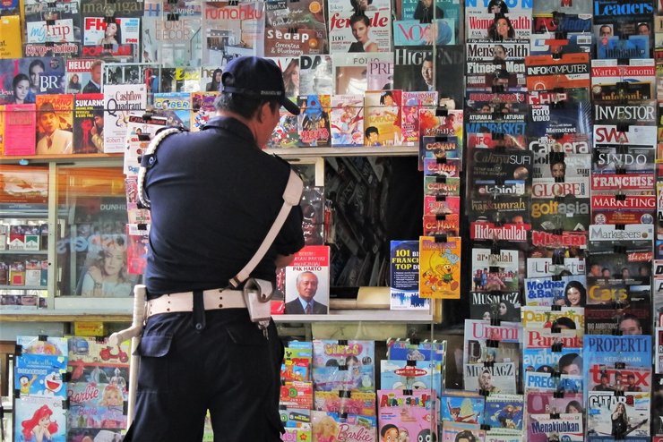 Indonesian Policeman looking at magazines