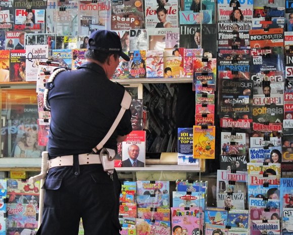 Polizist vor Zeitschriftenstand in Indonesien