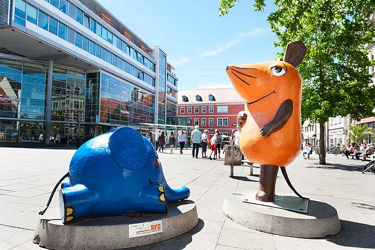 Die Zeichentrickfiguren die Maus und der kleine Elefant als Statuen am Anger