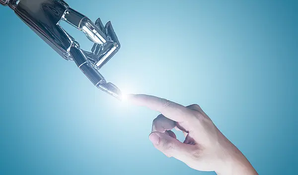 Die Zeigefinger einer Roboterhand und einer menschlichen Hand berühren sich und an dem Punkt, an dem sie sich berühren erscheint ein Licht.